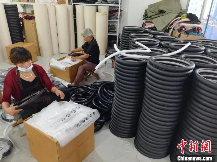 圖為村民在汽車飾品企業(yè)生產(chǎn)車間中工作?！巫雍?攝