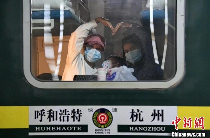 圖為登上轉(zhuǎn)運火車的游客向額濟納比心。　王磊 攝