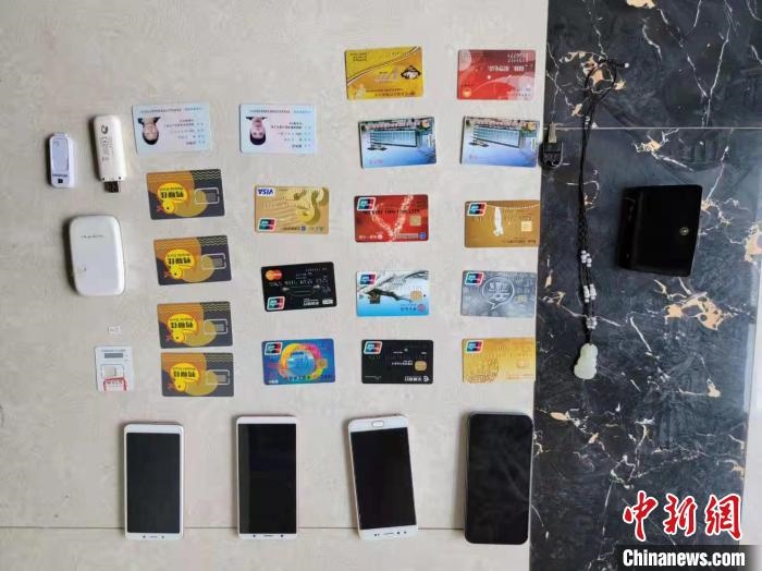 資料圖為果洛藏族自治州公安民警查扣的作案手機和涉案銀行卡?！‖斍呖h公安局供圖