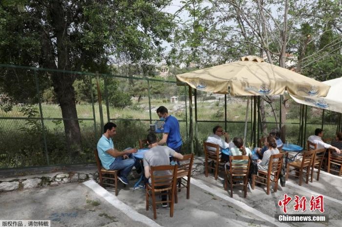 資料圖：希臘雅典，人們在一家露天咖啡享用飲品。