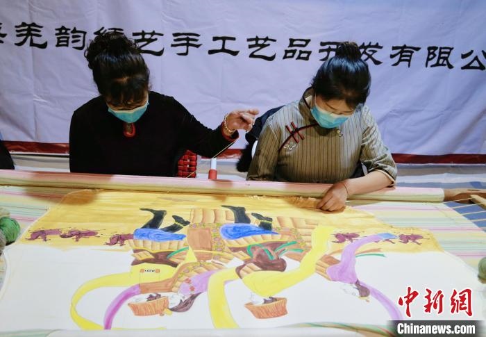 圖為皮繡藝人在市集上“秀”指尖技藝?！●R銘言 攝