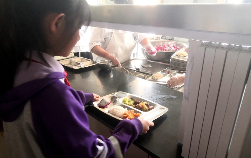 伊金霍洛旗第一小學(xué)學(xué)生正在打飯，今天的飯菜是三菜一湯外加水果，學(xué)生可以多次盛取，吃飽為止。人民網(wǎng)記者 孫博洋攝