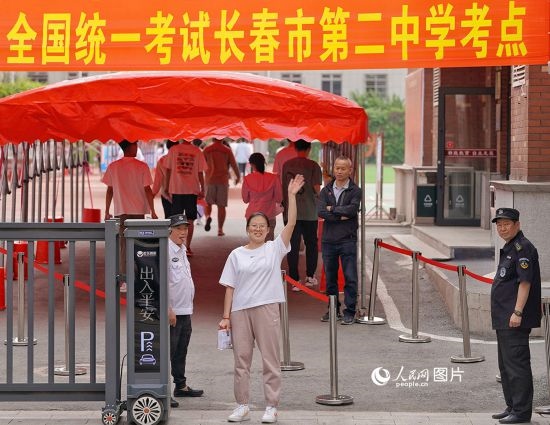 6月7日，在長春市第二中學(xué)考點，一名考生信心滿滿進入考場，并與家長揮手致意。人民網(wǎng)記者 李洋攝