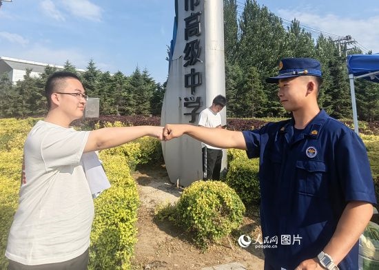 6月7日，遼寧營口老邊區(qū)消防救援大隊的消防員為高考學(xué)子加油助威。人民網(wǎng)記者 尹柏寒?dāng)z