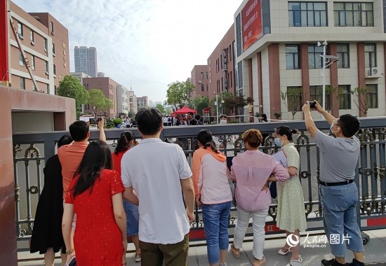 6月7日，武漢市第三中學(xué)考點，考生進場后，家長在柵欄外用手機拍攝自己的孩子。人民網(wǎng)記者 郭婷婷攝