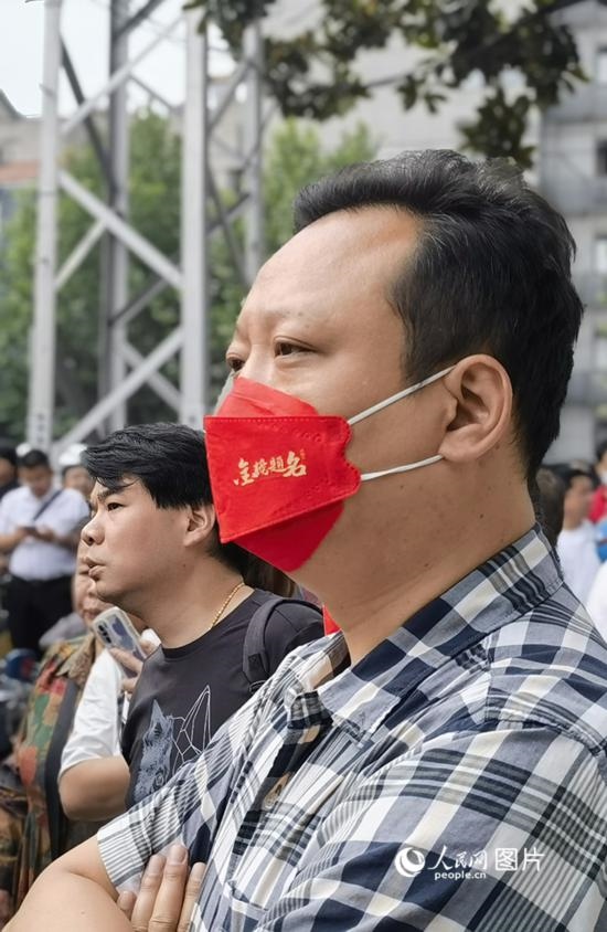 6月7日早，在武漢市第二十六中學(xué)考點外，送考家長戴著印有“金榜題名”的口罩。人民網(wǎng) 周雯攝