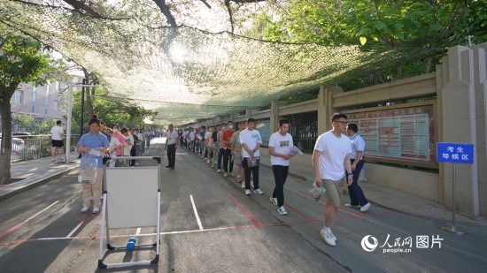 6月7日，烏魯木齊市第七十中學(xué)門口，考生們有序進入考場。人民網(wǎng) 李欣洋攝