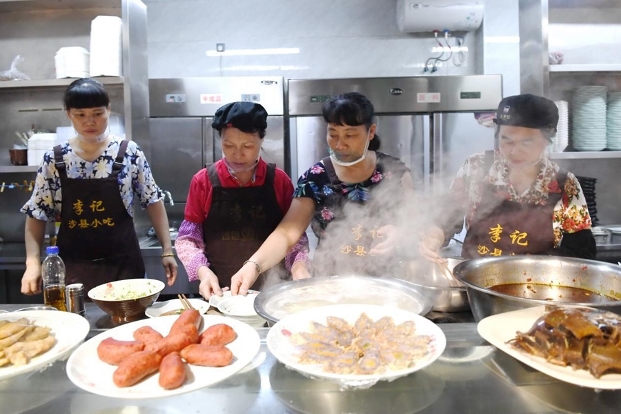 福建三明市沙縣區(qū)一家小吃店工作人員在為客人準(zhǔn)備特色小吃。 新華社記者 林善傳 攝