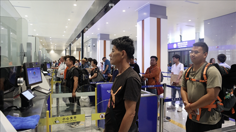 6月13日，乘坐中老鐵路國(guó)際旅客列車的旅客在磨憨邊檢大廳排隊(duì)候檢。李揚(yáng) 攝