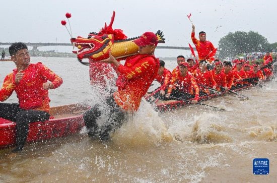 6月22日，在湖南省岳陽(yáng)市湘陰縣湘江臨資口水域，參加龍舟賽的隊(duì)員接“龍頭”下水。