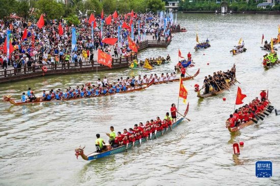 6月23日，在貴州省黔東南苗族侗族自治州施秉縣舉行的獨(dú)木龍舟節(jié)上，獨(dú)木龍舟進(jìn)行水上巡游。