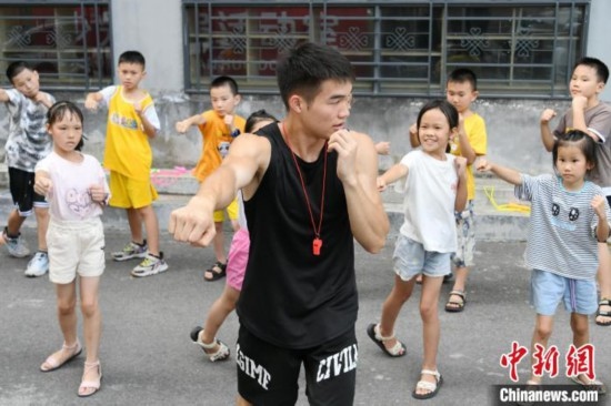 圖為大學(xué)生志愿者在組織孩子們參加體育健身活動(dòng)。廖光福 攝