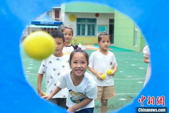 在肥西縣山南鎮(zhèn)中心幼兒園，孩子們在玩布洞投球游戲。陳家樂 攝