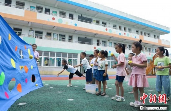 在肥西縣山南鎮(zhèn)中心幼兒園，孩子們在玩布洞投球游戲。陳家樂 攝