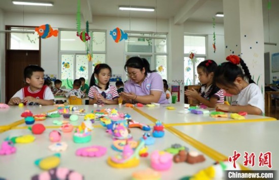 在肥西縣山南鎮(zhèn)中心幼兒園，孩子們在老師的指導下做彩色泥塑。陳家樂 攝