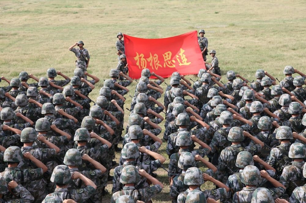 ↑“楊根思連”官兵執(zhí)行任務(wù)前向連旗宣誓（資料照片）。新華社發(fā)