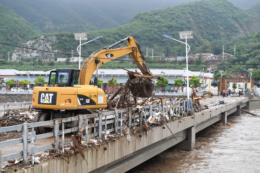 8月1日，在北京市門頭溝區(qū)水峪嘴村村口，一臺挖掘機在清理阻斷橋梁交通的雜物。目前該條道路已經(jīng)疏通完成。新華社記者 鞠煥宗 攝