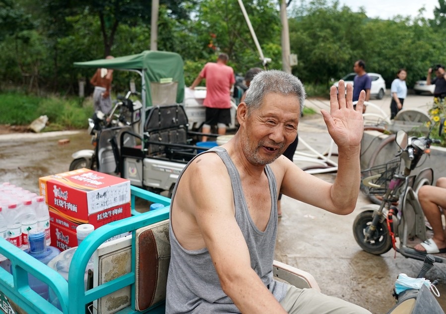 8月5日，從安置點回來的北京市房山區(qū)青龍湖鎮(zhèn)口頭村村民高大爺領(lǐng)到生活物資準(zhǔn)備回家。新華社記者 張晨霖 攝