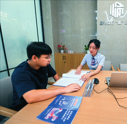 在杭州市臨安區(qū)政務(wù)服務(wù)中心的“為企服務(wù)中心”，黨員志愿者（右）解答企業(yè)主的疑問（2023年7月7日攝）。徐昱攝/本刊