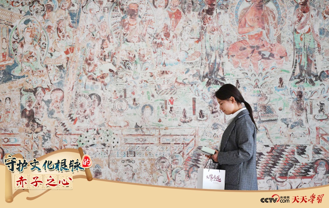 2023年4月25日，敦煌研究院文物數(shù)字化保護(hù)團(tuán)隊(duì)創(chuàng)意營(yíng)銷(xiāo)人員廖雪婷從一幅高保真復(fù)制壁畫(huà)前走過(guò)。