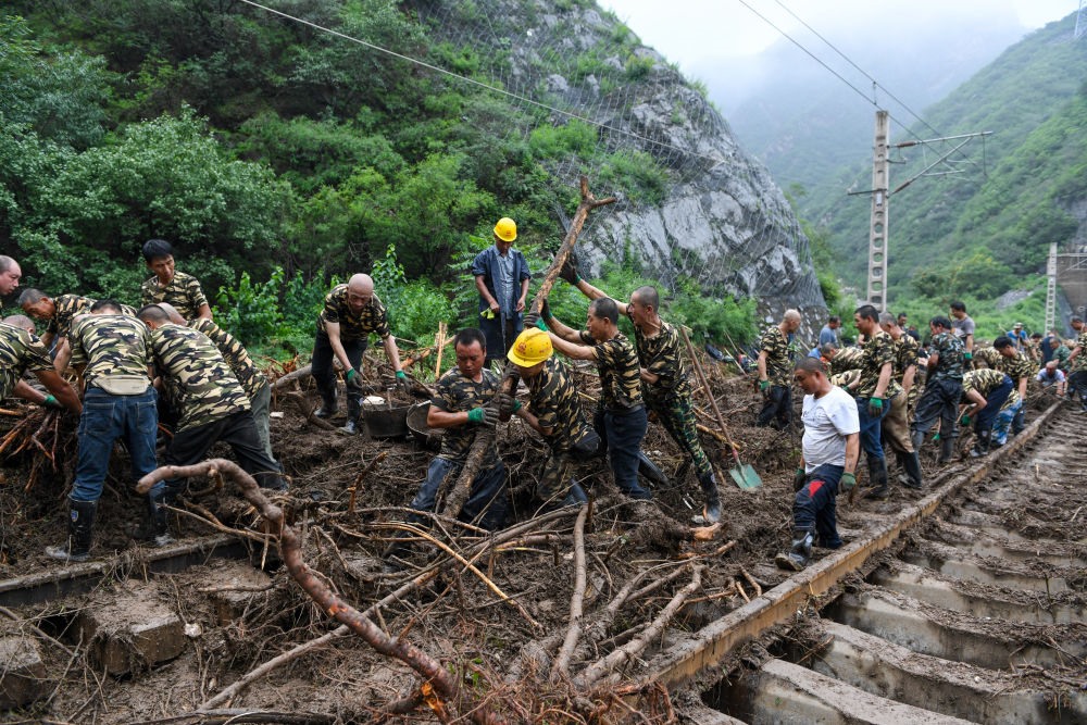 8月1日，在北京市門頭溝區(qū)水峪嘴村附近一段被阻斷的鐵路線上，中鐵六局工作人員在清理軌道上的雜物，全力恢復(fù)交通。新華社記者 鞠煥宗 攝