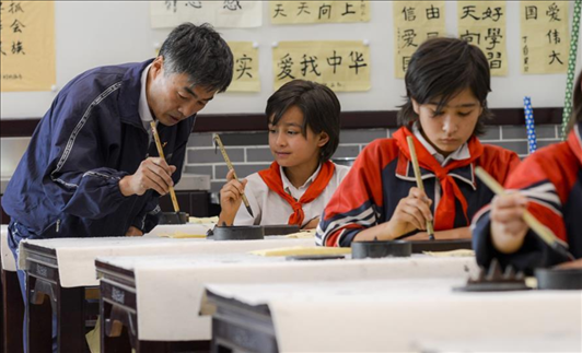 △新疆疏附縣托克扎克鎮(zhèn)中心小學書法教室內(nèi)，同學們正在學習寫毛筆字。