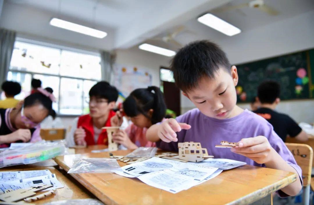 △今年7月，在浙江余姚市舜北小學暑托班內(nèi)，孩子們制作太陽能科學實驗裝置。
