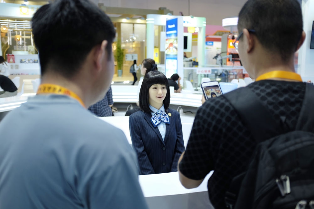 9月1日，媒體記者在國家會議中心與服務(wù)機器人互動。新華社記者 劉夢琪 攝