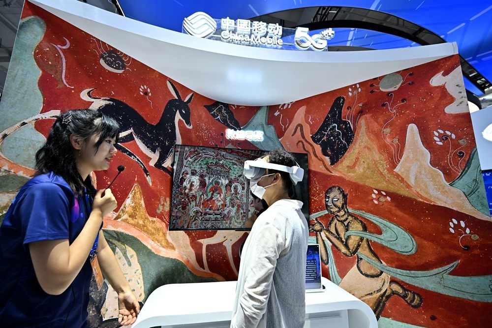9月3日，一名參觀者在首鋼園中國移動展臺體驗基于AR/VR特效的敦煌導覽，沉浸式感受敦煌壁畫的魅力。新華社記者 李鑫 攝