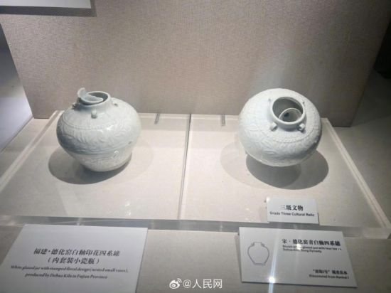 福建德化窯白釉印花四系罐（左）。人民網記者 李娜攝