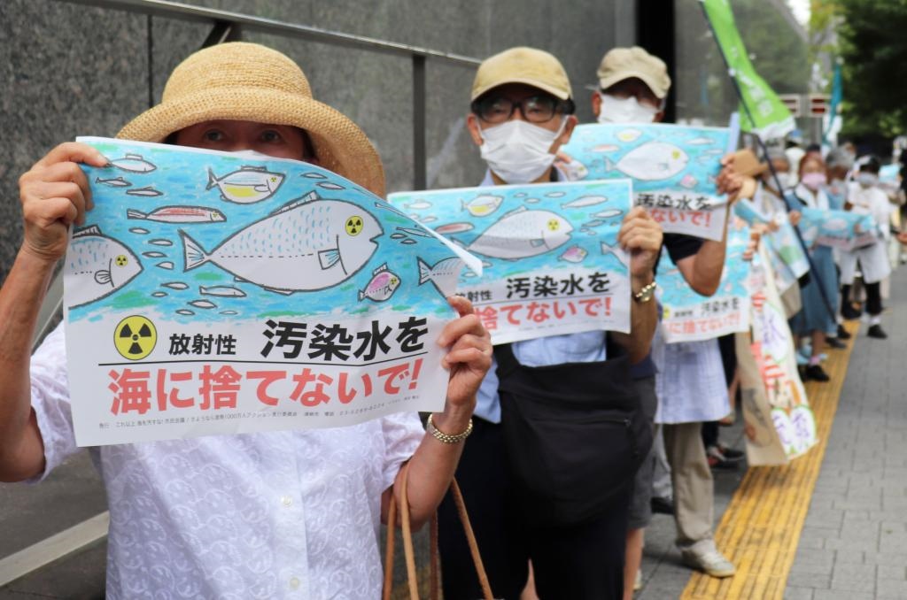8月24日，日本民眾手持“不要將污染水扔進(jìn)大海”等標(biāo)語(yǔ)在東京電力公司總部前集會(huì)，抗議日本政府和東電公司無(wú)視民意啟動(dòng)核污染水排海。新華社記者楊光攝