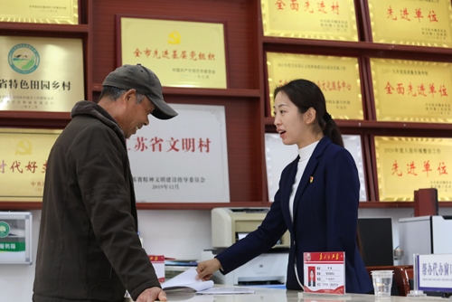 李敏在雙蕩村便民服務(wù)大廳接待前來辦理業(yè)務(wù)的村民。受訪者供圖
