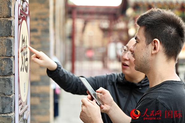 選手安德烈（俄羅斯）在老師指導(dǎo)下學(xué)習(xí)墻壁上張貼的生僻字。人民網(wǎng) 盧鵬宇攝
