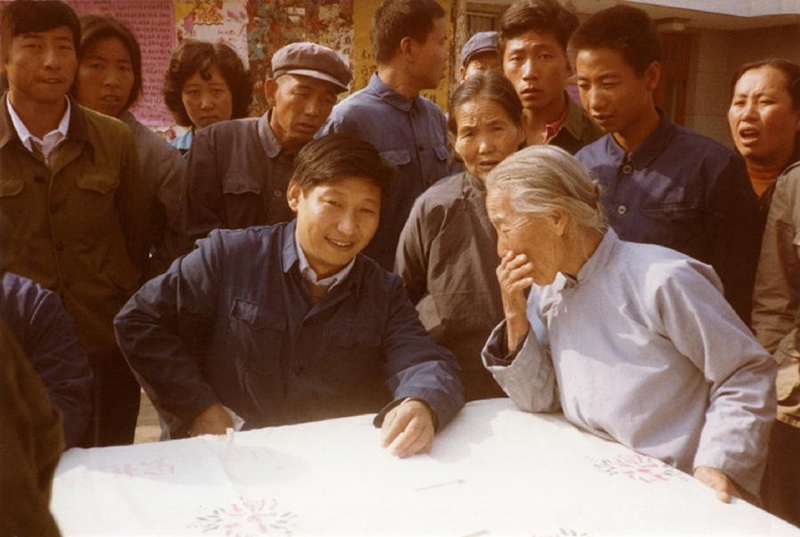 1983年，時(shí)任河北正定縣委書記的習(xí)近平（前排居中）臨時(shí)在大街上擺桌子聽取老百姓意見。