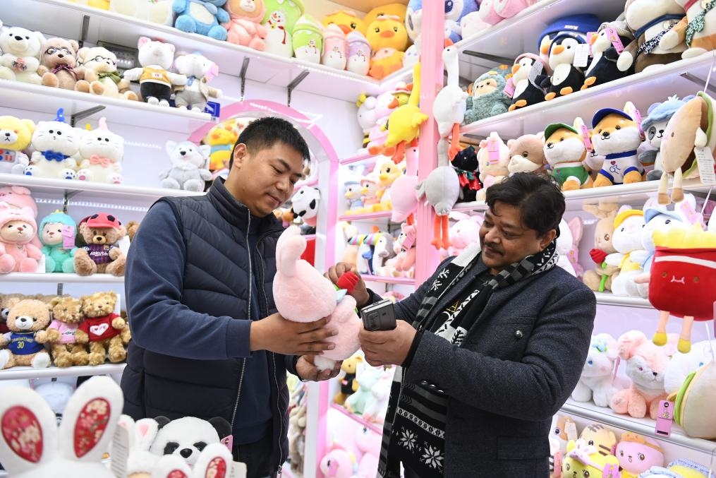 2023年2月2日，來自印度的客商（右）在義烏國際商貿(mào)城的一家玩具店鋪內(nèi)選購商品。新華社記者 黃宗治 攝