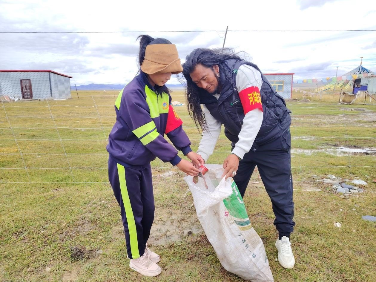 玉樹(shù)州稱多縣珍秦鎮(zhèn)河湖志愿者才培和他女兒更求拉毛在清掃垃圾。受訪者供圖