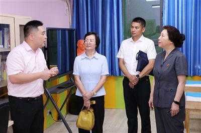圖③：“小公民法律課堂”開(kāi)講前，全國(guó)人大代表殷其龍（右二）、重慶市人大代表李自玲（左二）聽(tīng)取楊家坪中學(xué)負(fù)責(zé)人關(guān)于未成年人思想教育工作情況的介紹。