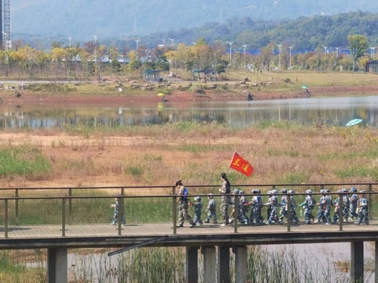 10月24日，秋游的幼兒園小朋友在老師帶領(lǐng)下走在清水塘公園里的木橋上。本報記者 常雯宜攝