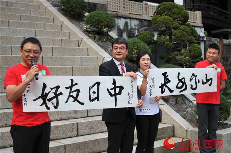 東京中國文化中心主任羅玉泉展示其為本次活動(dòng)書寫的題詞“中日友好，山高水長”。人民網(wǎng) 蔣曉辰攝