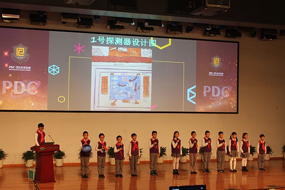 北京呼家樓中心小學(xué)的學(xué)生們展示PDC項(xiàng)目“新行星移民計(jì)劃探索衛(wèi)星設(shè)計(jì)”。