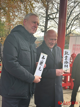 柏林市長(zhǎng)韋格納（右）、動(dòng)物園監(jiān)事會(huì)主席布魯克曼（左）手持中國(guó)文化中心工作人員現(xiàn)場(chǎng)手書(shū)的中文名字。人民網(wǎng)記者 徐馨攝
