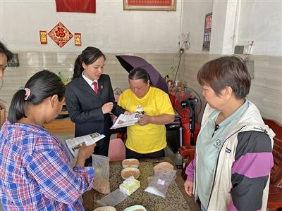  圖⑤：龍圩區(qū)法院法官到群眾家中開展法治宣傳。資料圖片