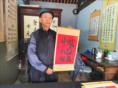 越南首都河內(nèi)文廟內(nèi)，阮明珠展示“中越心相近”書法作品。