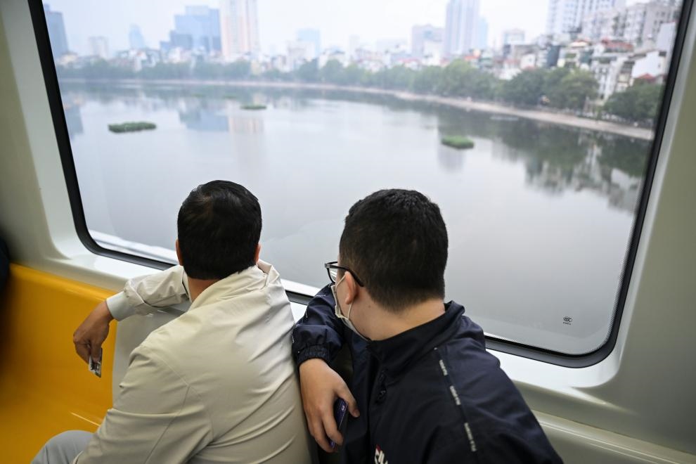 12月9日，市民在越南河內(nèi)輕軌二號線車廂內(nèi)透過車窗欣賞城市風(fēng)景。