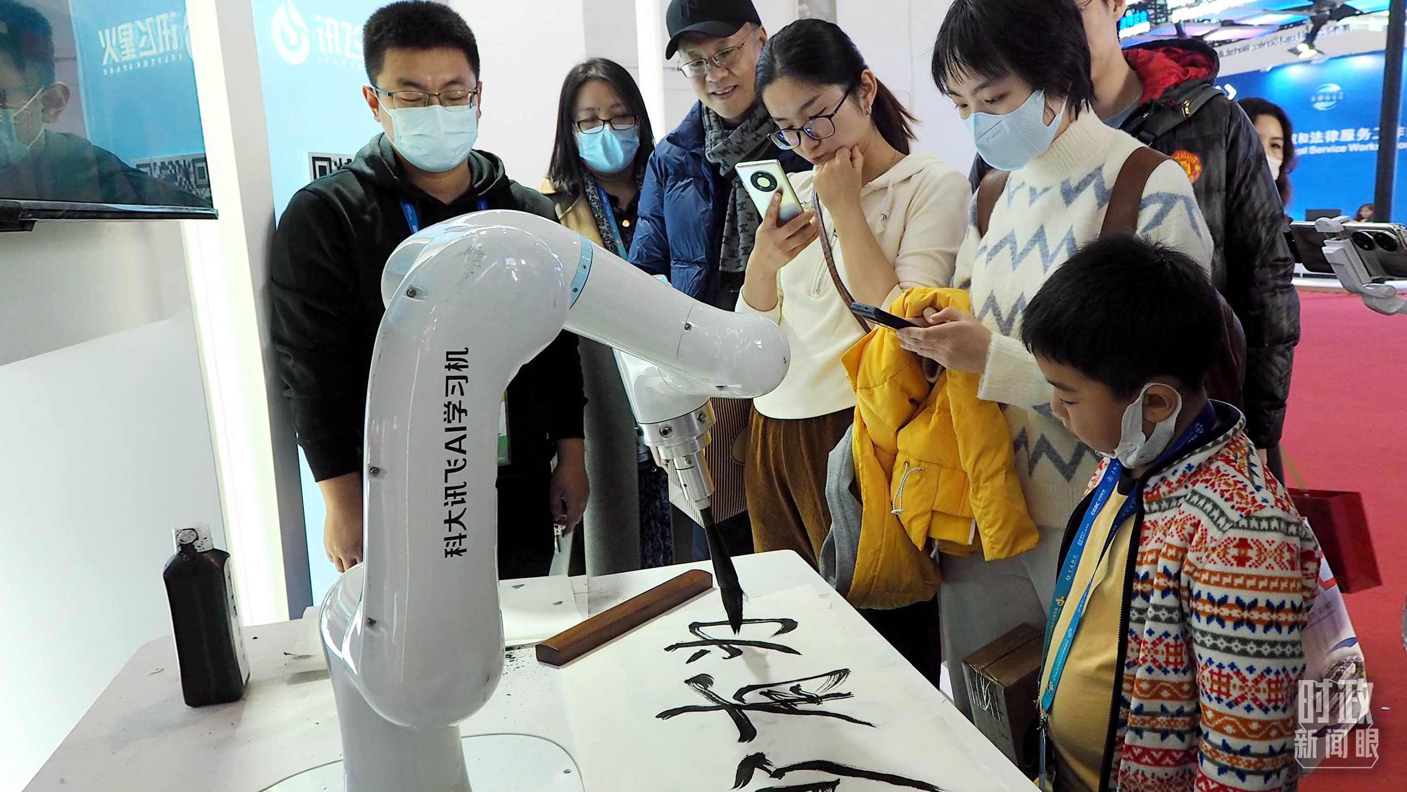 △觀眾在首屆鏈博會上體驗AI書法機器人。