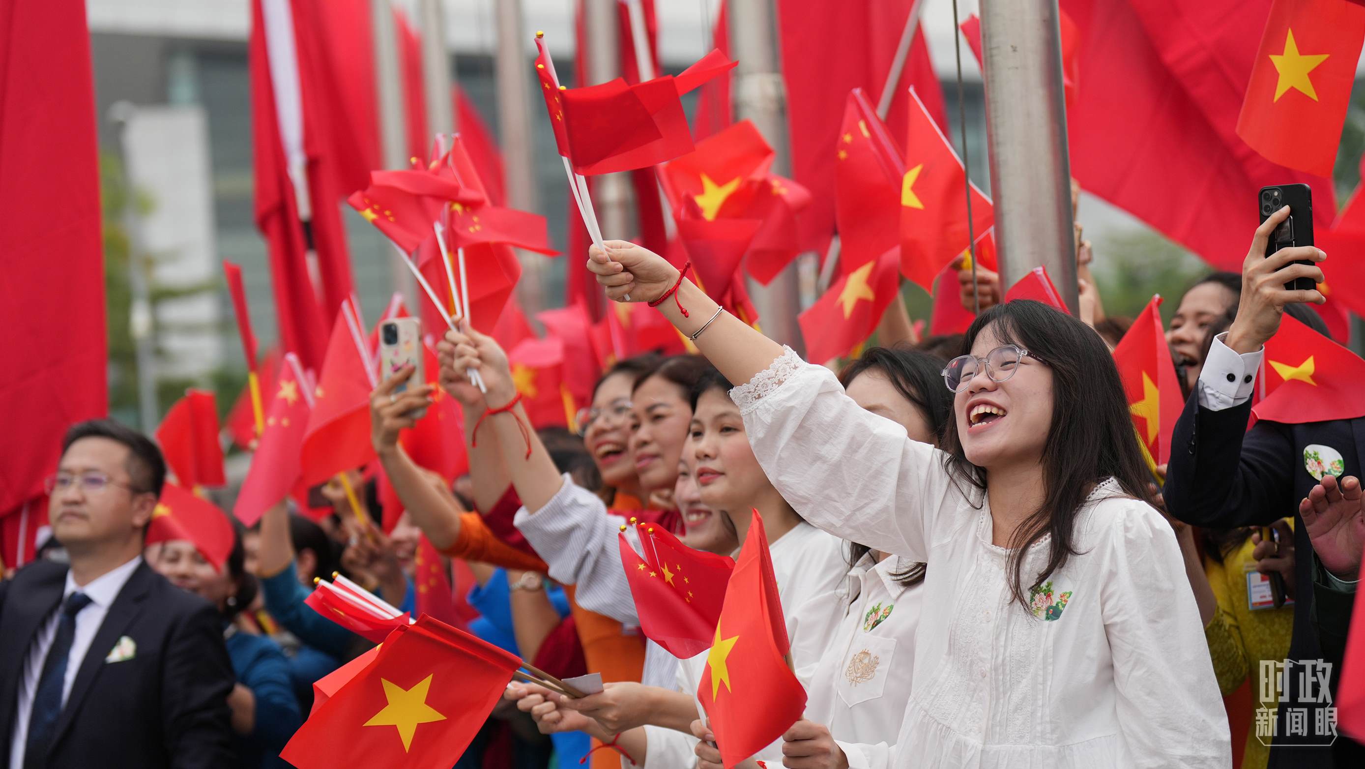 △人們揮舞兩國旗幟歡迎習(xí)近平訪越。（總臺國廣記者李晉拍攝）