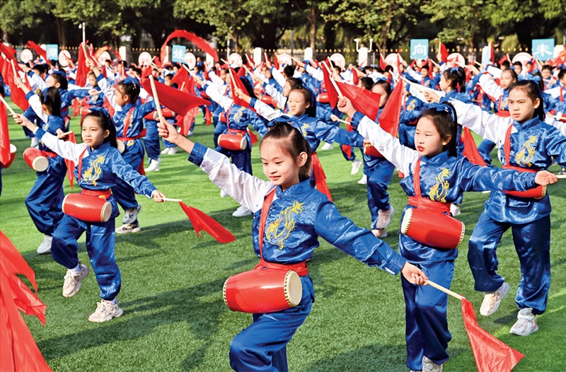 為助推民族地區(qū)基礎(chǔ)教育事業(yè)發(fā)展，廣西重新核定各地中小學(xué)教職工編制，依托全區(qū)編制“周轉(zhuǎn)池”核增事業(yè)編制給各地中小學(xué)，在全面達(dá)到國(guó)家標(biāo)準(zhǔn)的基礎(chǔ)上，進(jìn)一步統(tǒng)籌優(yōu)化和動(dòng)態(tài)調(diào)整各區(qū)域、學(xué)校、學(xué)段間編制資源。圖為2023年11月29日，南寧市濱湖路小學(xué)舉行主題為“逐夢(mèng)新時(shí)代 健體向未來(lái)”的體育文化節(jié)，孩子們正在跳腰鼓舞。 新華社記者 周華/攝
