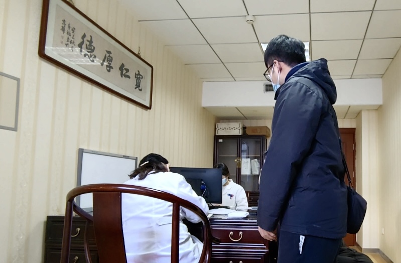 陪診師大飛陪同來(lái)京就診的患者在醫(yī)院?jiǎn)栐\。人民網(wǎng)記者 任妍攝