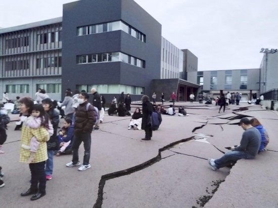  1月1日，在日本石川縣輪島市，人們站在被地震破壞的地面上。新華社/共同社