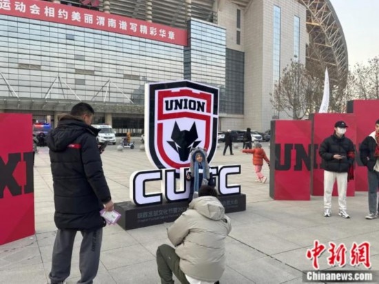 球迷們與隊(duì)徽合影。記者 卞立群 攝